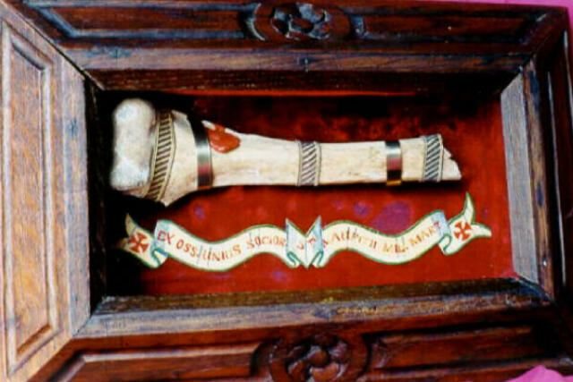 Upper arm bone relic with a red wax seal in a carved wooden frame