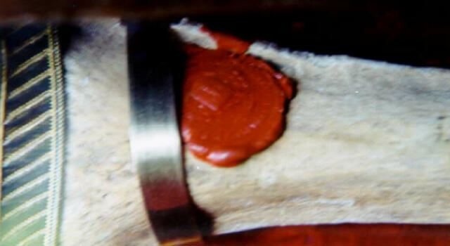 Close view of the red wax seal and metal band on the humerus relic