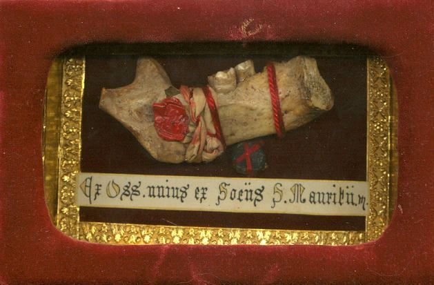 Jaw bone relic with two molars in a carved frame lined in red